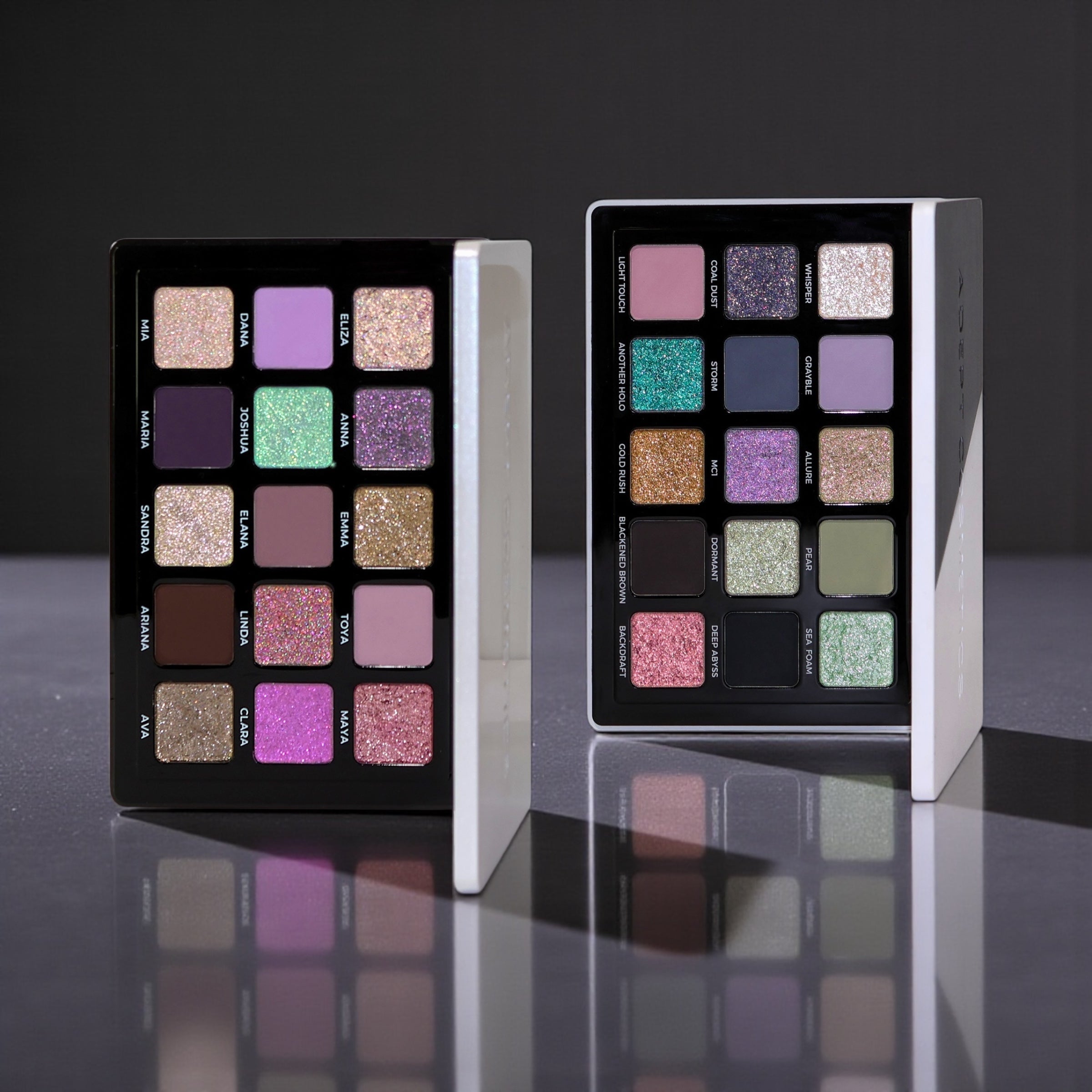 Two makeup palettes with colorful eyeshadow swatches on a reflective surface.